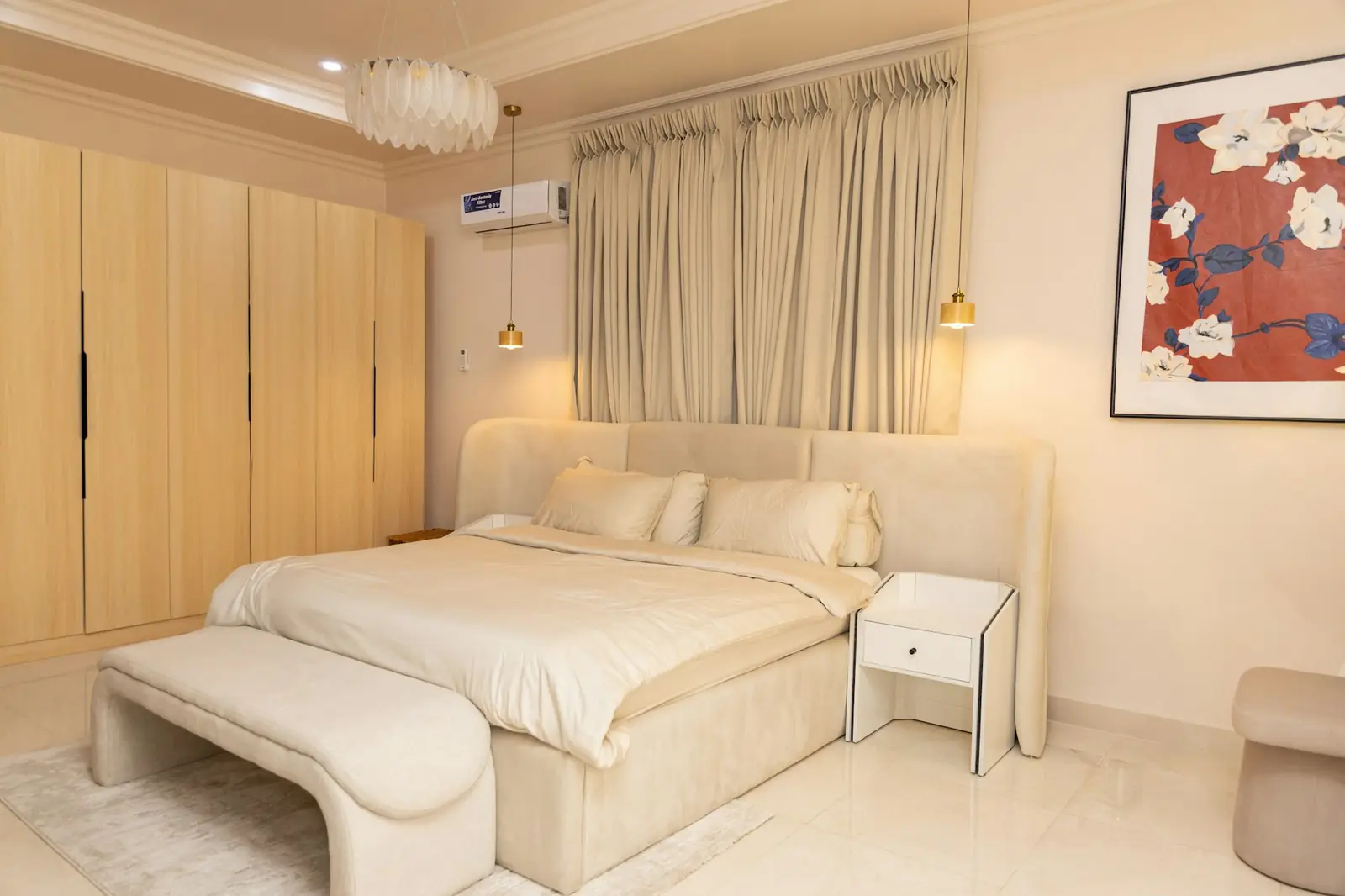 A calm bedroom with a wall-mounted air conditioning unit above the curtains